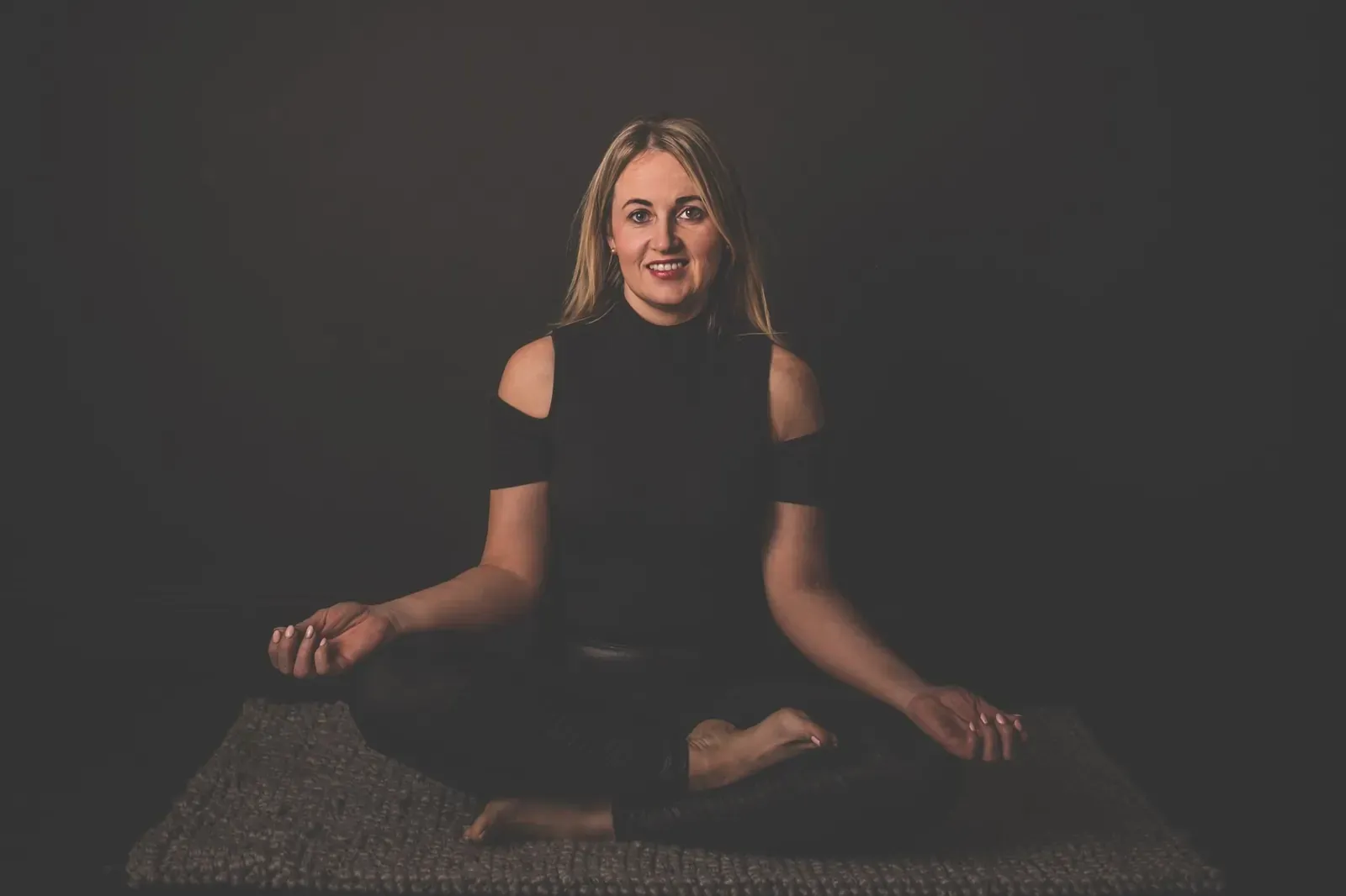 Fiona Mullen, the Athboy yoga teacher who teaches in Irish and English, seated on a mat